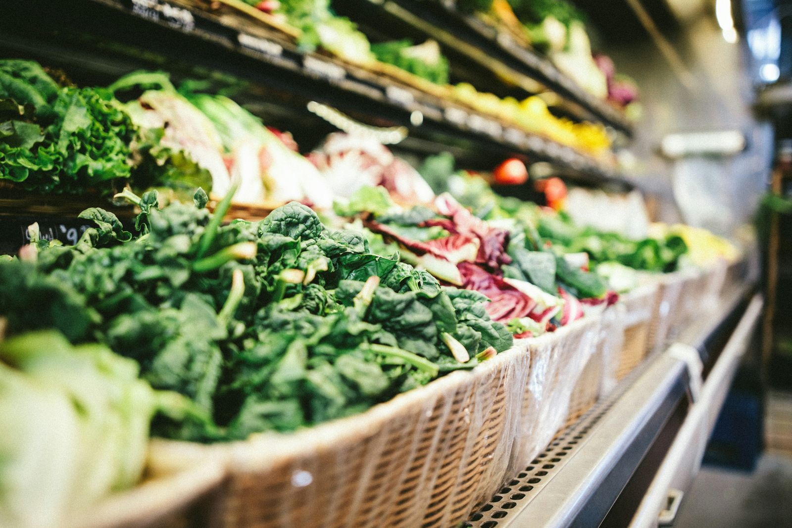Fresh leafy greens and assorted vegetables on display at a grocery store.